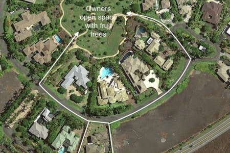An aerial map view showing several neighborhood properties highlighted in white outlines, with arrows pointing to a central grassy community area text-labeled "Owners open space with fruit trees."