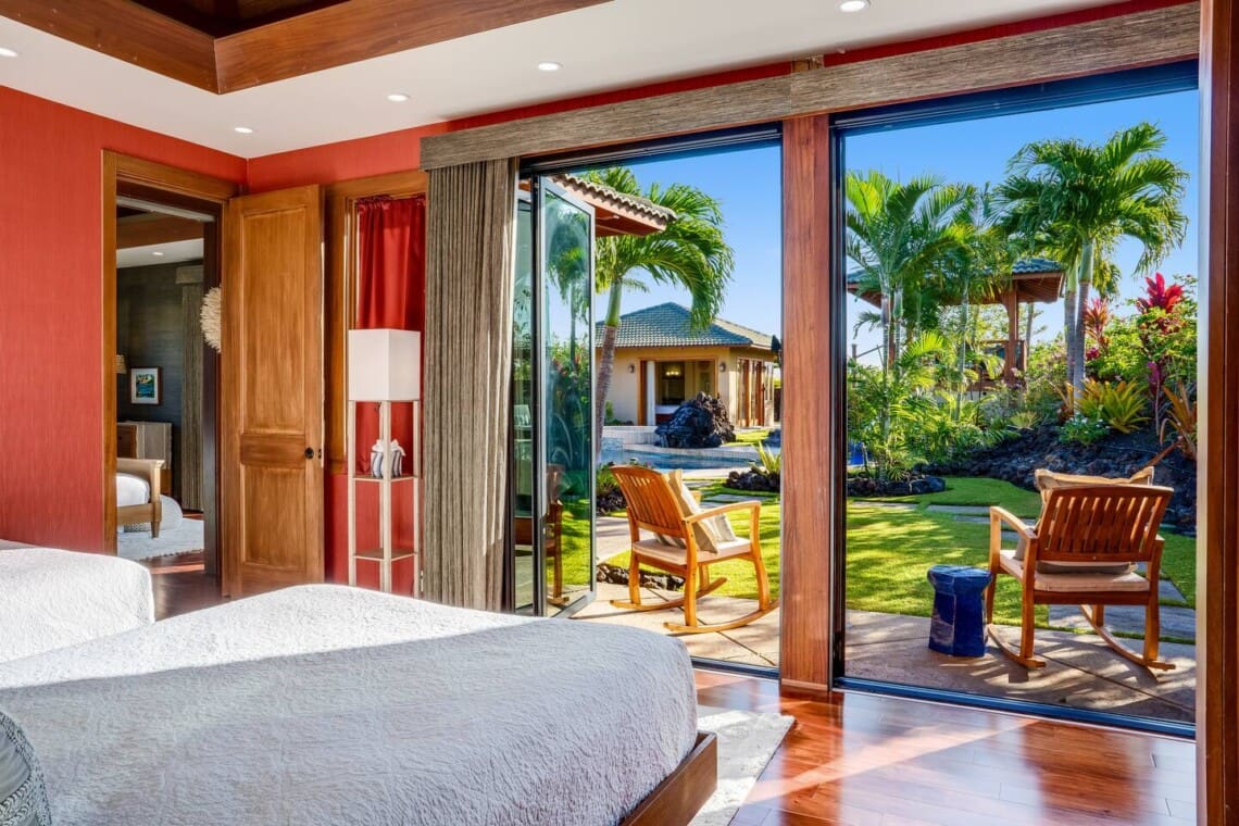 Bedroom 4 at Hale Mele with twin beds, a private patio, and tropical garden views in Mauna Lani on the Big Island of Hawaiʻi.