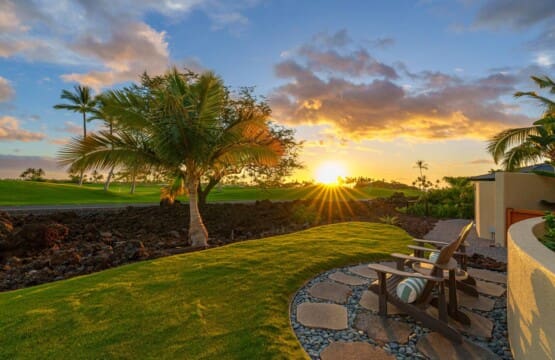 Sunset view from the tropical garden with Adirondack chairs overlooking the Mauna Lani golf course at Hale Mele on the Big Island of Hawaii.