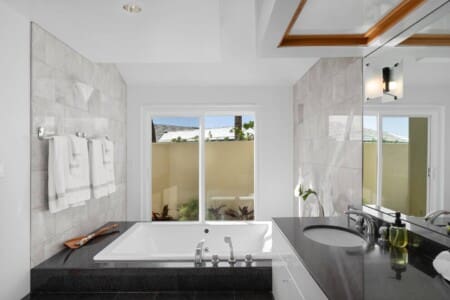 Primary bathroom with soaking tub, dual vanity, and spa-inspired design at Hale Mele luxury vacation rental in Mauna Lani.