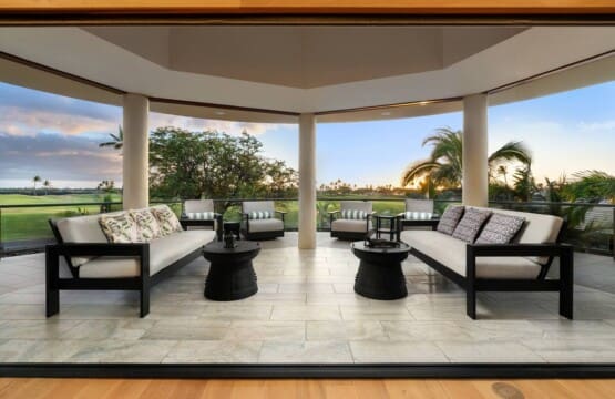 Covered outdoor lanai with lounge seating overlooking the Mauna Lani golf course at sunset.